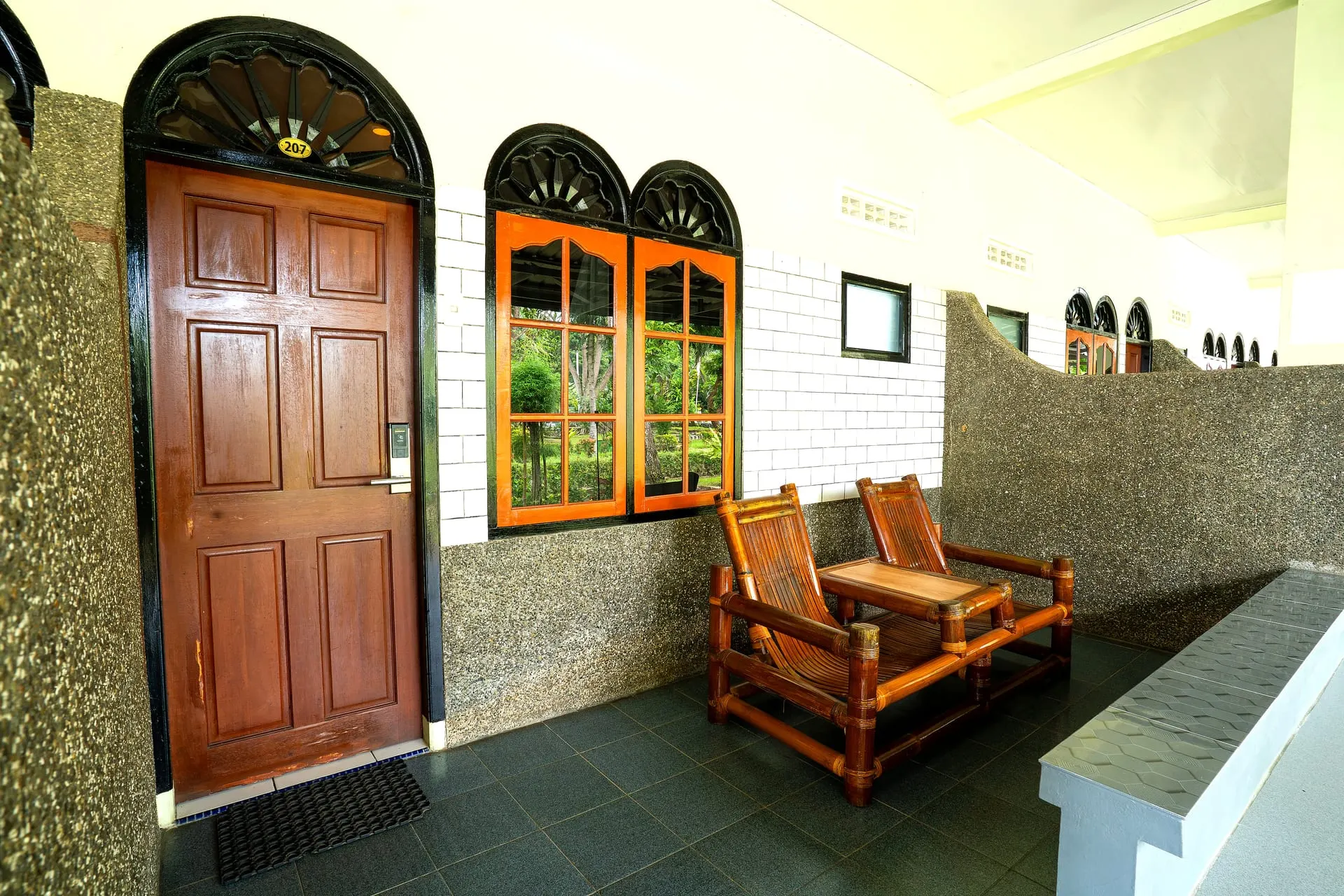 Terrace with bamboo chairs outside a room