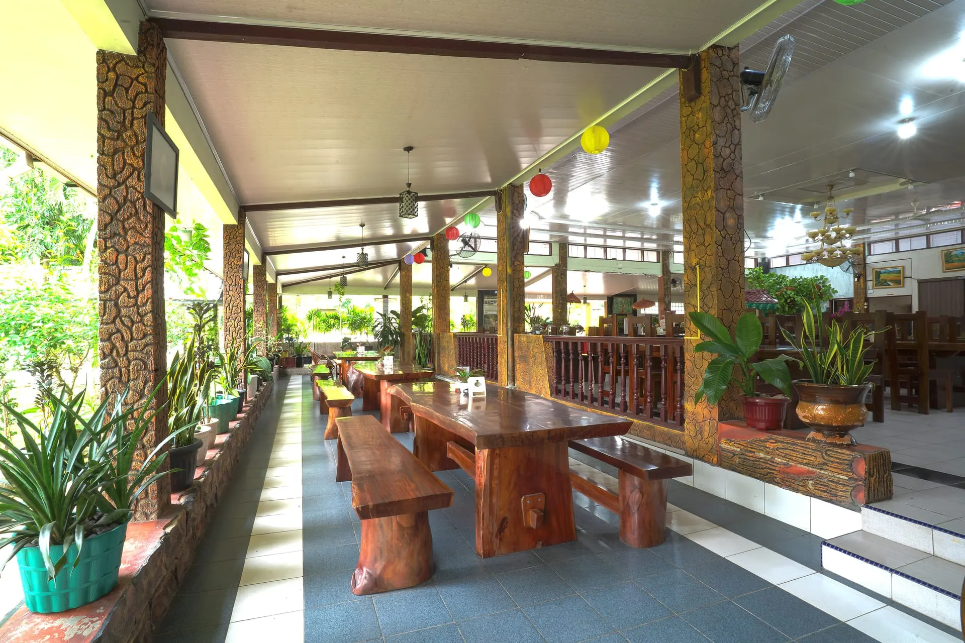 Open-air restaurant with carved wooden tables